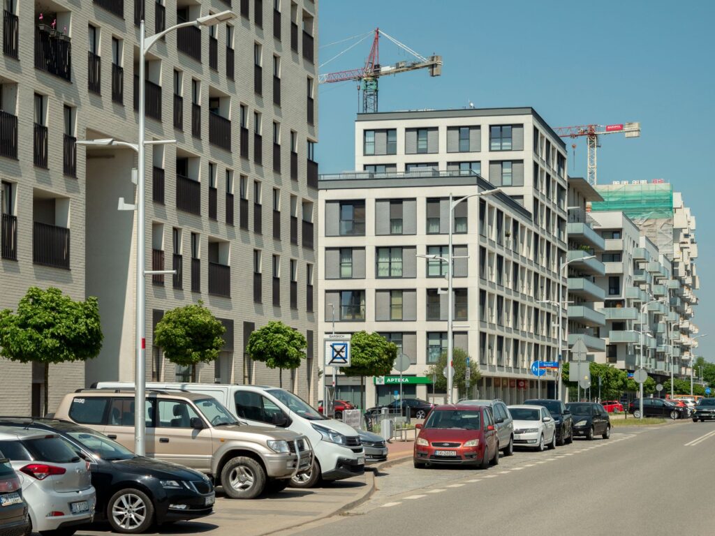 Budynki mieszkalne i żurawie budowlane przy ulicy we Wrocławiu