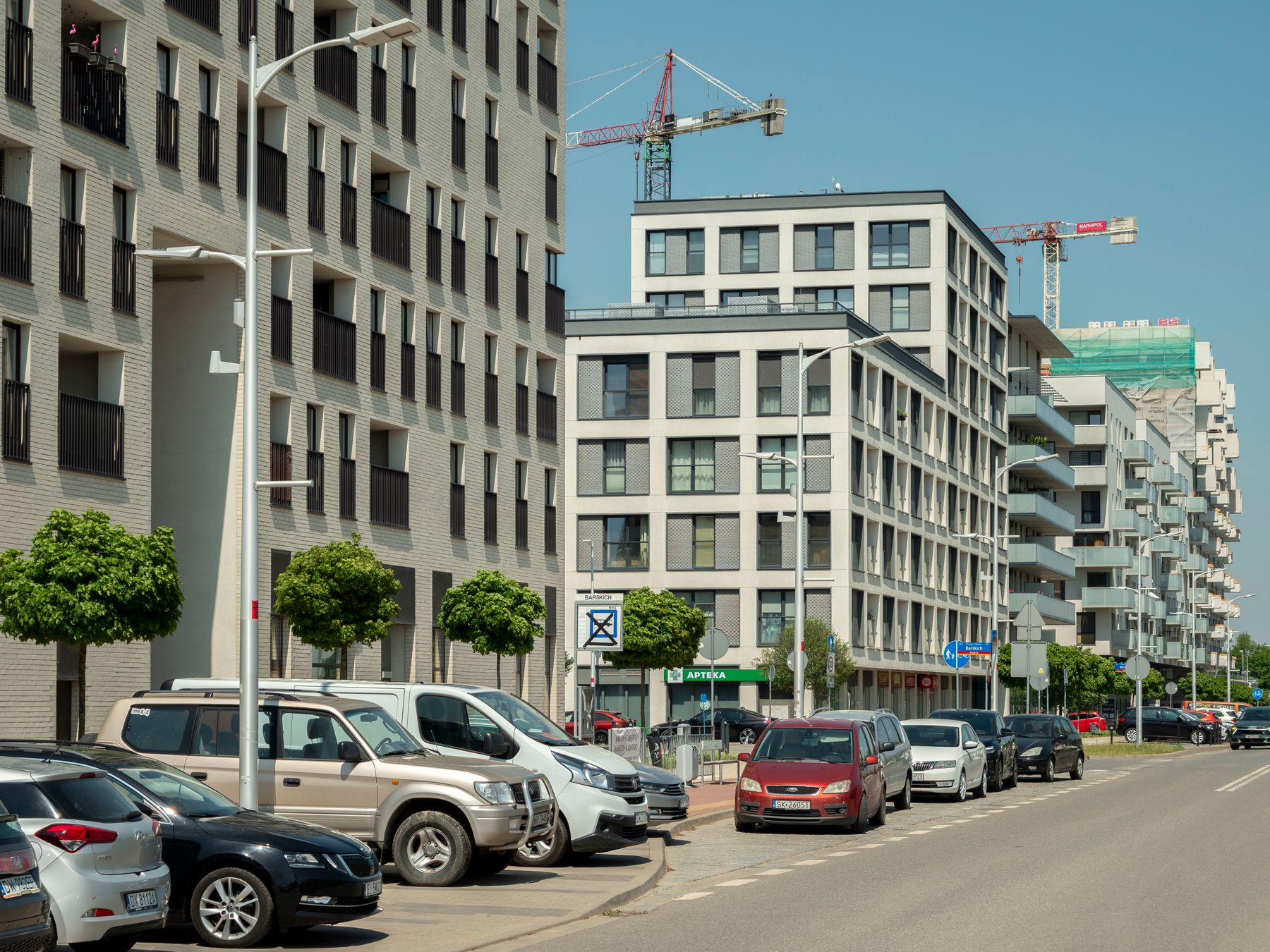 Budynki mieszkalne i żurawie budowlane przy ulicy we Wrocławiu